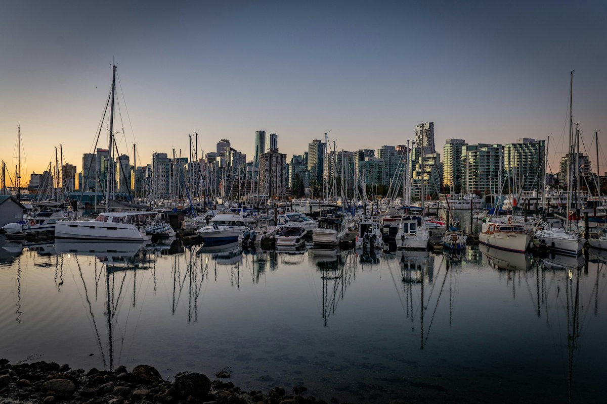 Sailboats in Coal Harbour marina at dawn with downtown Vancouver beyond
