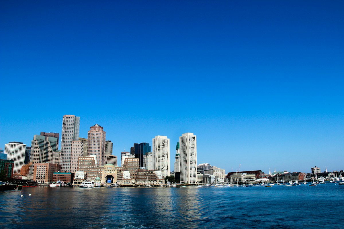 Boston skyline and Rowes Wharf across the harbour under a clear blue sky