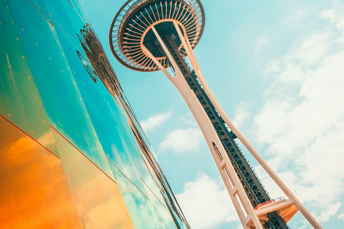 Space Needle rising above the Museum of Pop Culture under a blue sky